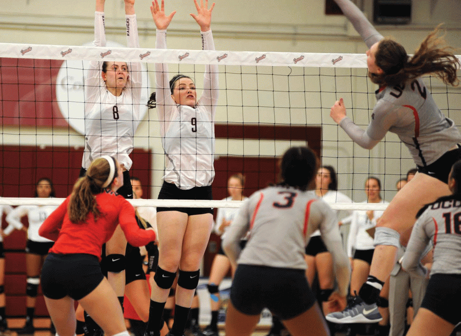 First-year middle blocker Taylor Flaherty and senior outside hitter Kathleen Harris pop up to block a spike. 