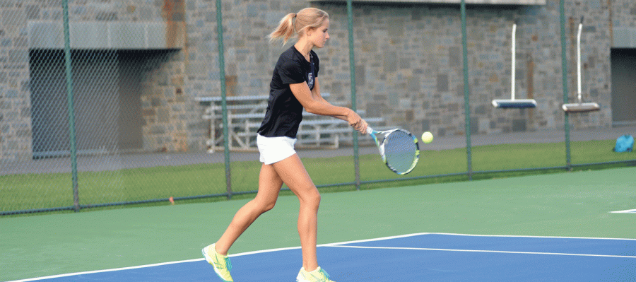 Senior tennis star Kirstie Woodbury helps sweep the Holy Cross Crusaders 7-0 in  a double header this past weekend. The men’s and women’s victories secured Coach Pennington his 200th career win.