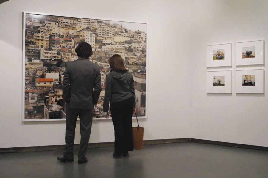 Art enthusiasts examine one of the photographs of the Israel or West Bank region in the new exhibit at the Picker Art Gallery.