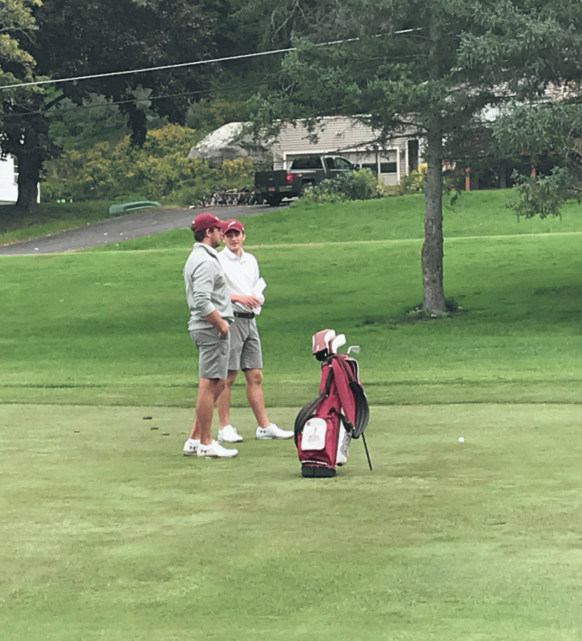 Junior Ryan Skae discusses his approach shot on the 18th with Coach Keith Tyburski. Skae finished the competition +21, good for second on the team.